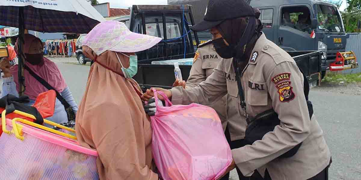 Polwan Polres Mimika membagikan paket sembako pada warga, Kamis (19/08/21). Foto: Humas Polres Mimika